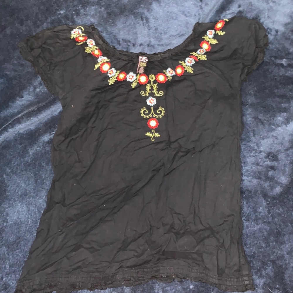 It is a black shirt with flower embroidery.